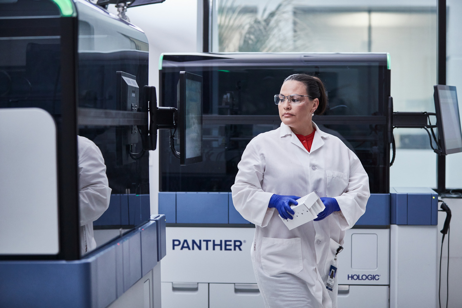 Lab technician walking through Panther systems in lab setting.
