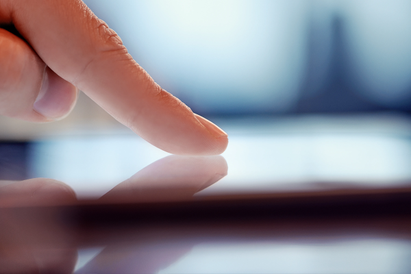 A closeup of a human finger touching a digital display.