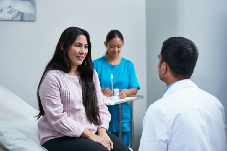 Female patient smiling to healthcare professional in examination room