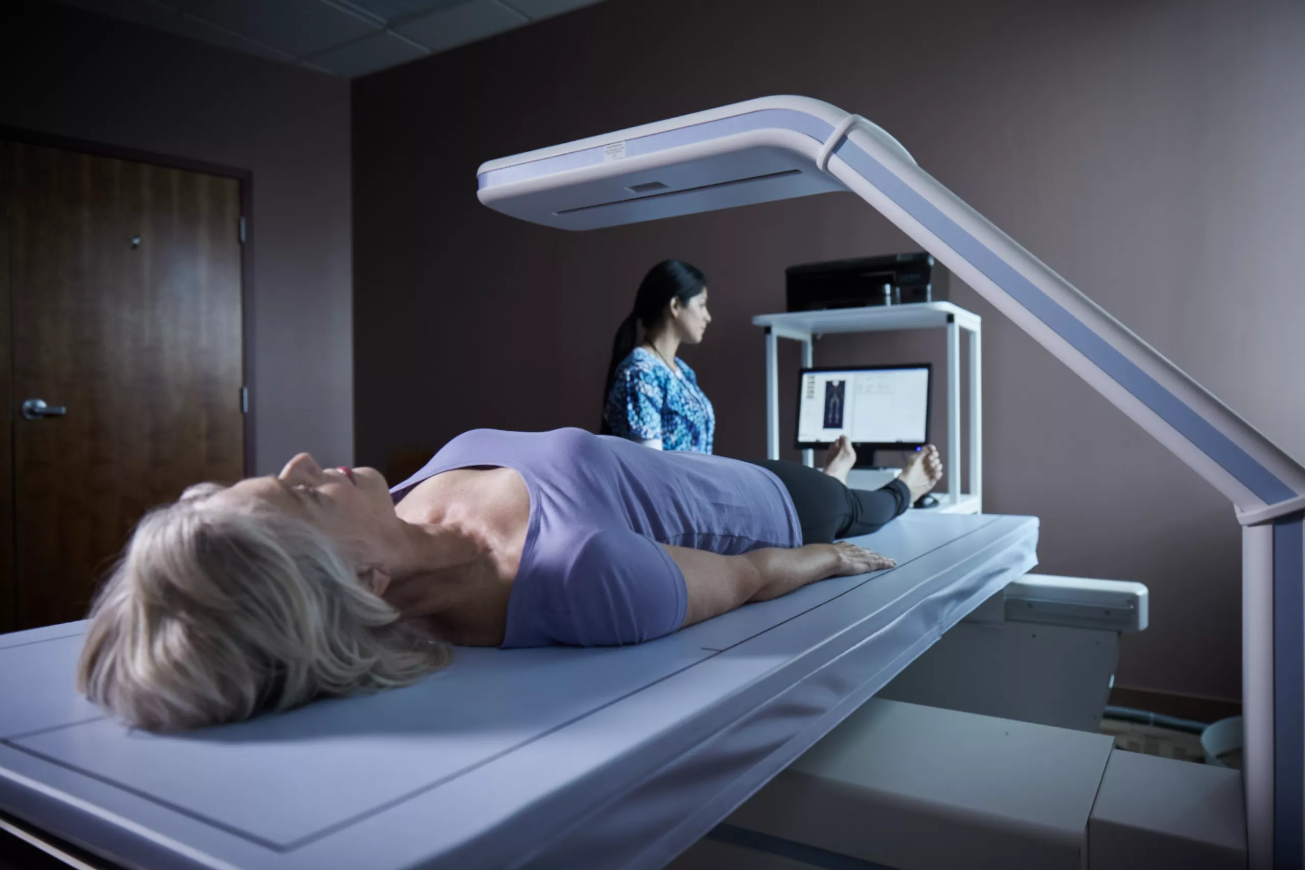 Patient lays on scanning table in lab setting.