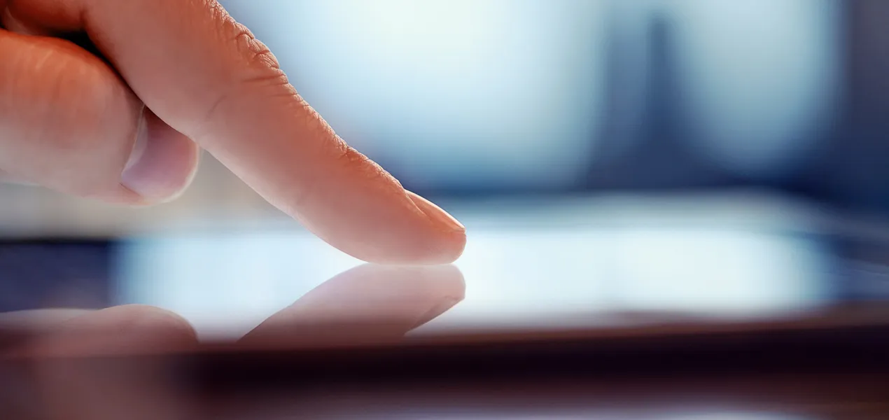 Closeup of a human finger touching a digital screen