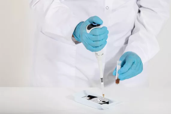Lab technician adding sample to cartridge in a lab setting