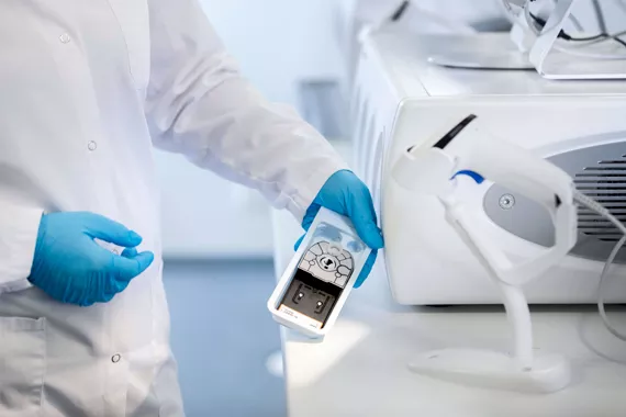 Lab technician scanning cartridge in a lab setting