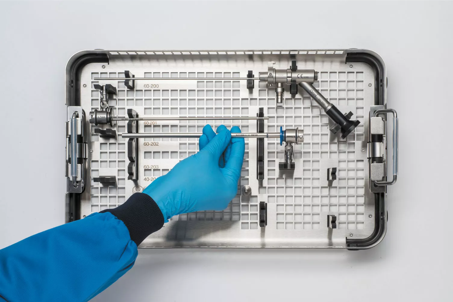 Gloved hand working medical tray on table.