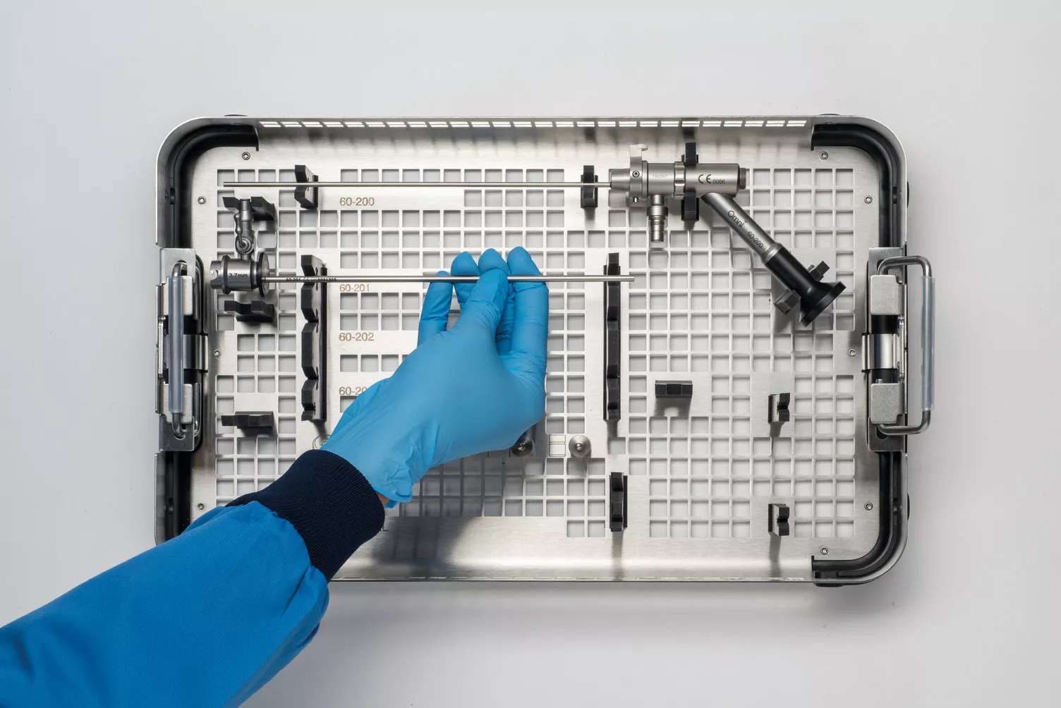 Gloved hand working medical tray on table.